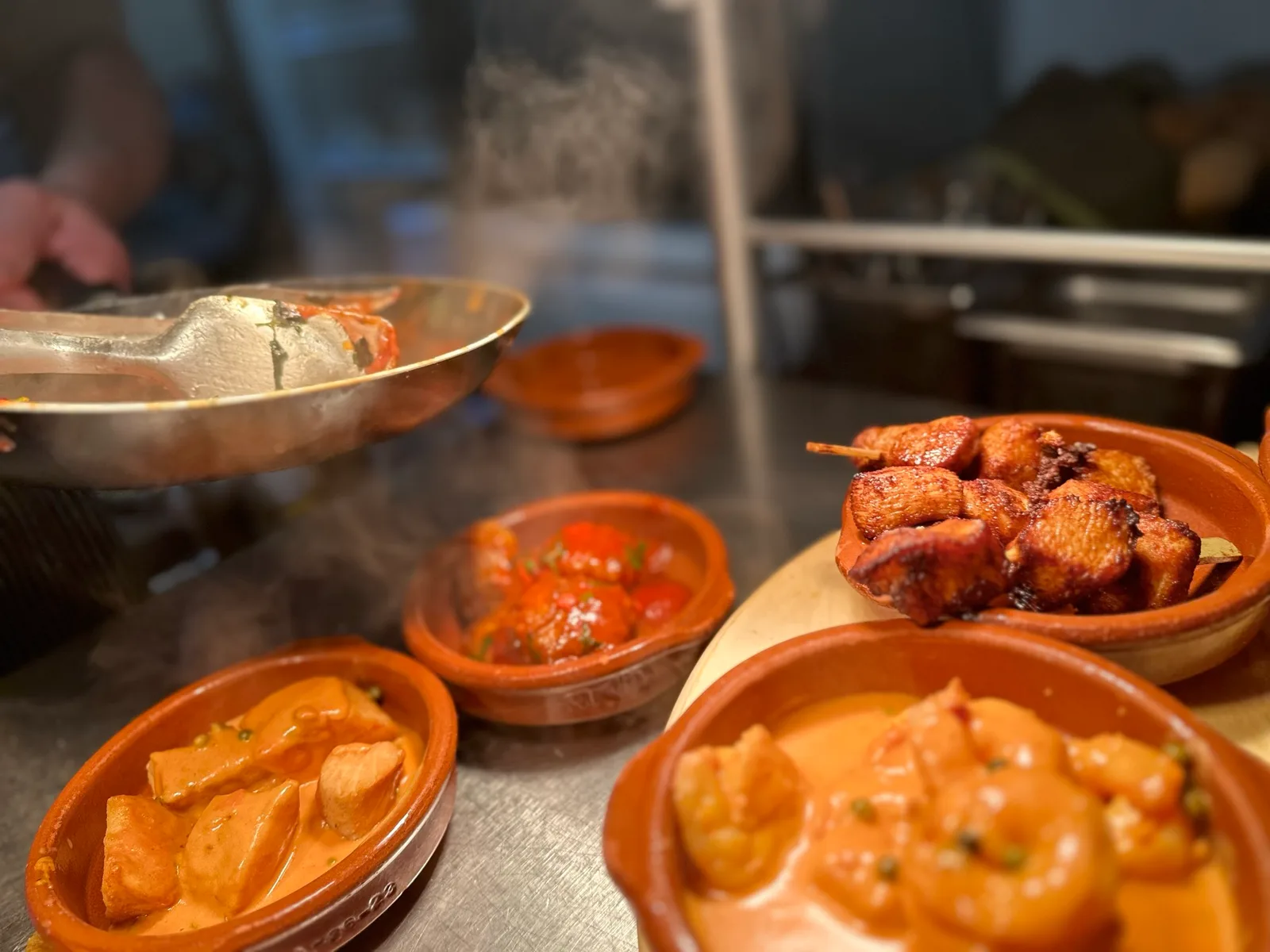 Pfanne und bereitgestellte Tapasschalen in der Restaurantküche